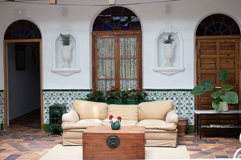 Espacio exterior con encanto, pintado de blanco y amueblado con butacas de mimbre