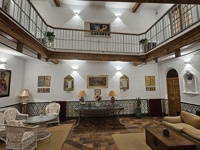 Patio interior pintoresco de dos niveles con barandilla de forja verde