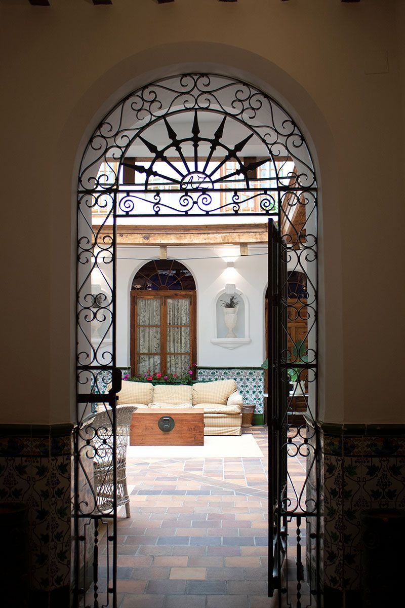 Puerta con marco de forja que accede al patio