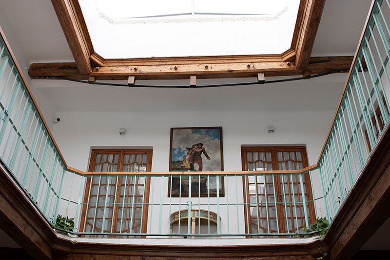 patio interior con dos niveles y elegante barandilla de forja verde